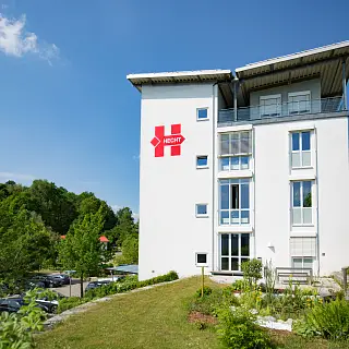 Gebäude der Firma HECHT mit rotem Frimenlogo an der Fassade