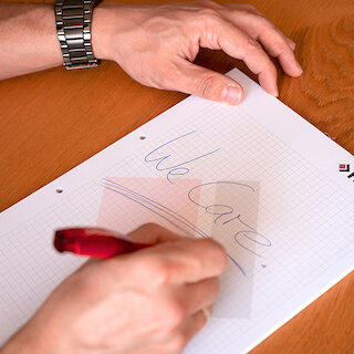 Person schreibt etwas auf einen Block